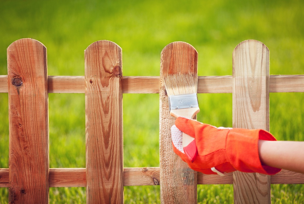 Part of maintaining your wood fence is applying stain periodically.